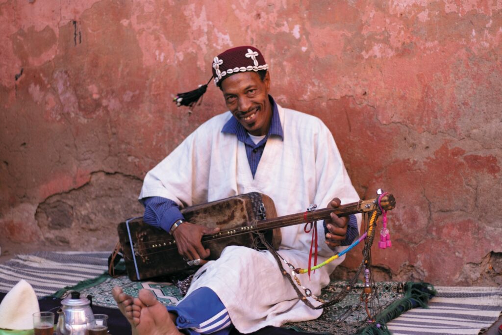 man playing brown guitar